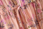 Pink Color option, Floral Printed Dress with Ruffles and tassels for that perfect pullover bohemian Women's short dress.  Close up image of cinched elastic waist with bow and tassels. 